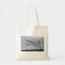 Bare tree branches against a cloudy sky tote bag