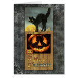 Black cat on a wooden fence with pumpkin cards