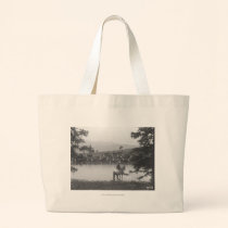 Cattle by a pond with two cowboys. bags