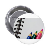 Colour pencils on a notepad pins