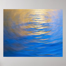 Gently rippled water reflecting gold and blue posters