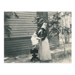 lady with bonnet putting child on seat post card