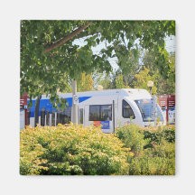 Light rail train seen through landscape. refrigerator magnet