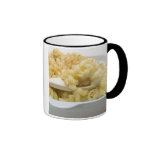 Macaroni cheese in baking dish with wooden coffee mugs