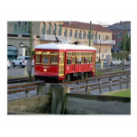 Red electric streetcar on tracks post card