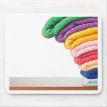 Stack of colourful microfiber towels toppling mouse mats