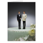 Two groom figurines on top of wedding cake greeting card