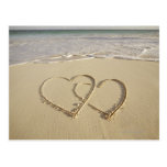 Two overlying hearts drawn on the beach post cards