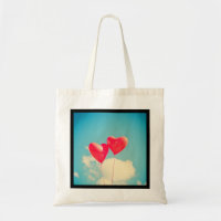 2 Bright Red Heart Shaped balloons Floating Upward