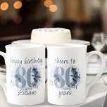 80th Birthday Cheers to 80 Years Floral Number Bone China Mug<br><div class="desc">80th birthday mug, with fully editable wording to personalise as you wish, such as "happy birthday [name]" and/or "cheers to 80 years". Design features number 80 decorated with rose buds, flower blooms and foliage in shades of coastal blue and sand. Subtle feminine and elegant design with watercolor floral arrangements, paint...</div>