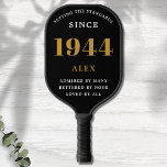 80th Birthday Name 1944 Black Gold Elegant Chic Pickleball Paddle<br><div class="desc">Chic '1944' 80th Birthday Black and Gold Personalised Pickleball Paddle - Elegant Design for Sports Enthusiasts. Celebrate a significant milestone in style with our chic '1944' 80th birthday black and gold pickleball paddle. Elegantly designed and fully personalised, this paddle blends birthday charm and utility in one. Ideal for anyone with...</div>