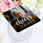 80th Birthday Party Photo White Script Cheers Square Paper Coaster<br><div class="desc">This custom 80th birthday paper coaster features the guest of honour's personalised photo,  name,  and birthday,  along with the word "Cheers" in elegant white calligraphy script. A dark screen helps make the text pop. A great way to celebrate someone who's turning eighty!</div>