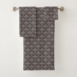 A bathroom towel set on a rack features