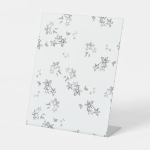 a black and white photo of snow flakes pedestal sign