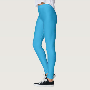 a blue background with a black and white cat on to leggings