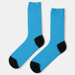 a blue background with a black and white cat on to socks