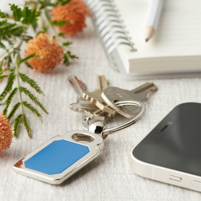 a blue background with a black and white clock key ring (Side)