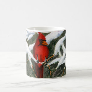 A bright red cardinal sets in a snow covered pine coffee mug