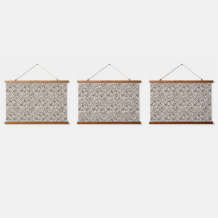 A brown rug with a geometric motif is partially co hanging tapestry