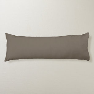 a brown wall with a black and white clock on it body cushion
