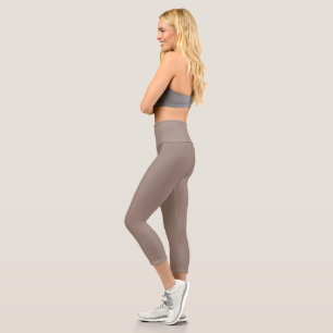 a brown wall with a clock on it capri leggings