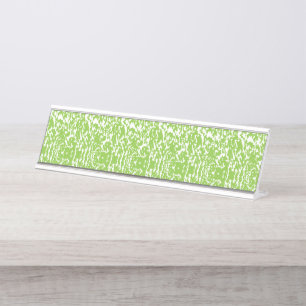 A brown wooden table holds a glass bottle of olive desk name plate