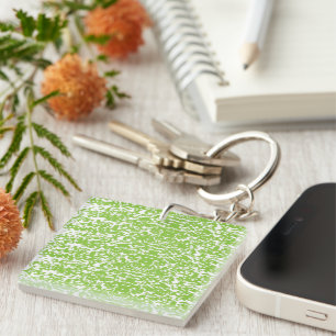 A brown wooden table holds a glass bottle of olive key ring