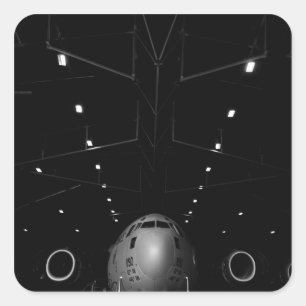 A C-17 Globemaster III sits in a hangar Square Sticker