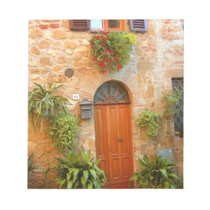 A cat seeks entrance to home in Pienza, Italy. Notepad