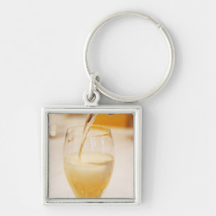 A champagne glass flute being filled with Gosset Key Ring