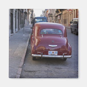 A classic old red Peugeot car parked on a street Magnet