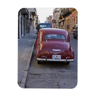 A classic old red Peugeot car parked on a street Magnet