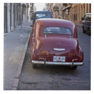 A classic old red Peugeot car parked on a street Tile