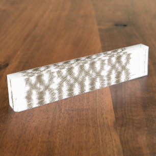 A close-up view of a crisscrossing wire mesh grid nameplate