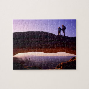 A couple watches sunrise from atop Mesa Arch in Jigsaw Puzzle