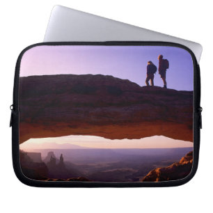 A couple watches sunrise from atop Mesa Arch in Laptop Sleeve