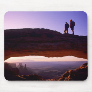 A couple watches sunrise from atop Mesa Arch in Mouse Pad