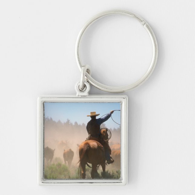 A cowboy out working the herd on a cattle key ring (Front)