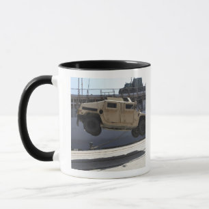 A crane lifts an M998 Humvee Mug