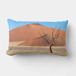 A dead tree on a desert plain with dunes lumbar cushion