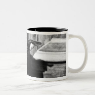 A dog peeking out from a door, close-up. Two-Tone coffee mug
