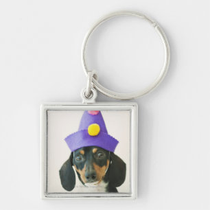 A dog wearing a funny hat key ring