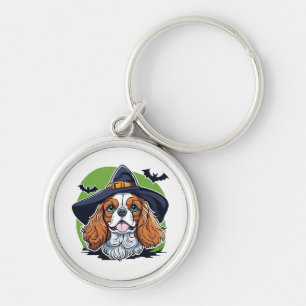 A dog wearing a witches hat with bats key ring