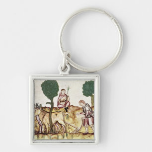 A farmer teaching his son to plough a field key ring