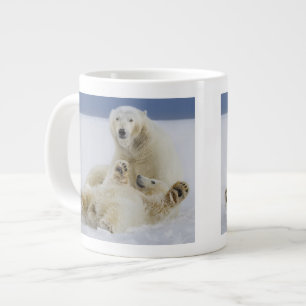 A female polar bear and her cub play in the snow large coffee mug