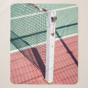 A FOCUSED SHOT OF A POST ON ONE SIDE OF A TENNIS N SHERPA BLANKET