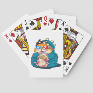 A funny hamster wearing glasses eats popcorn playing cards