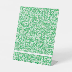 a green and white background with small white dots pedestal sign