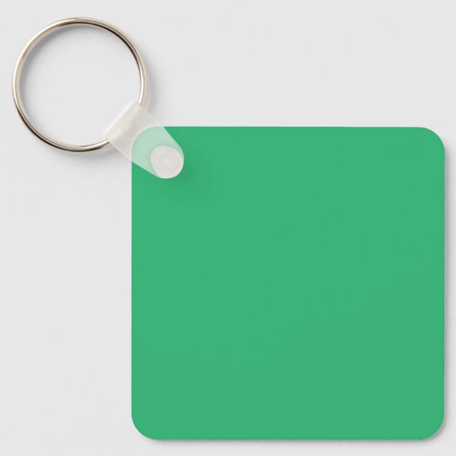 a green background with a white border key ring (Front)