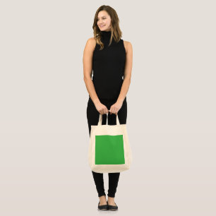 a green background with a white border tote bag